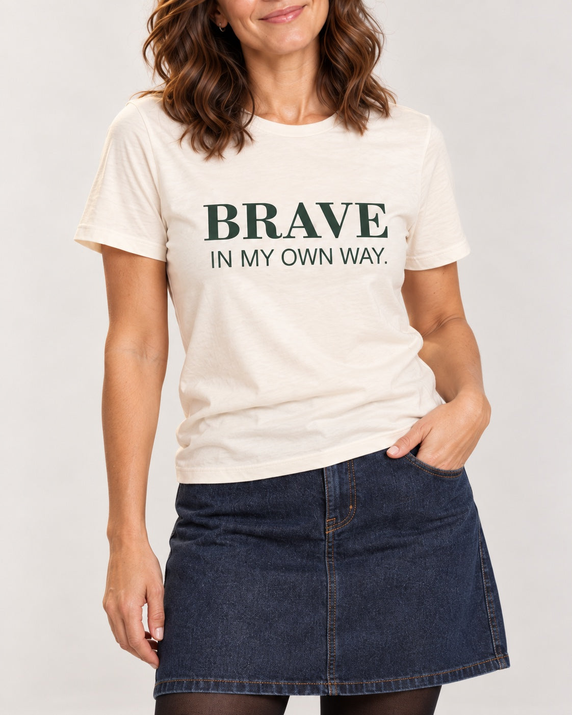Sophie wearing the Natural BRAVE IN MY OWN WAY. Bella+Canvas 3001 tee — collar-to-hip print detail