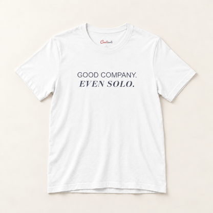 GOOD COMPANY. EVEN SOLO. Bella+Canvas 3001 tee in White, overhead view on a plain warm neutral studio background