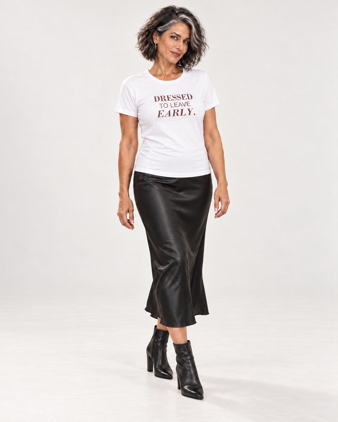 Freya wearing the White DRESSED TO LEAVE EARLY. Bella+Canvas 3001 tee — full-length natural studio outfit