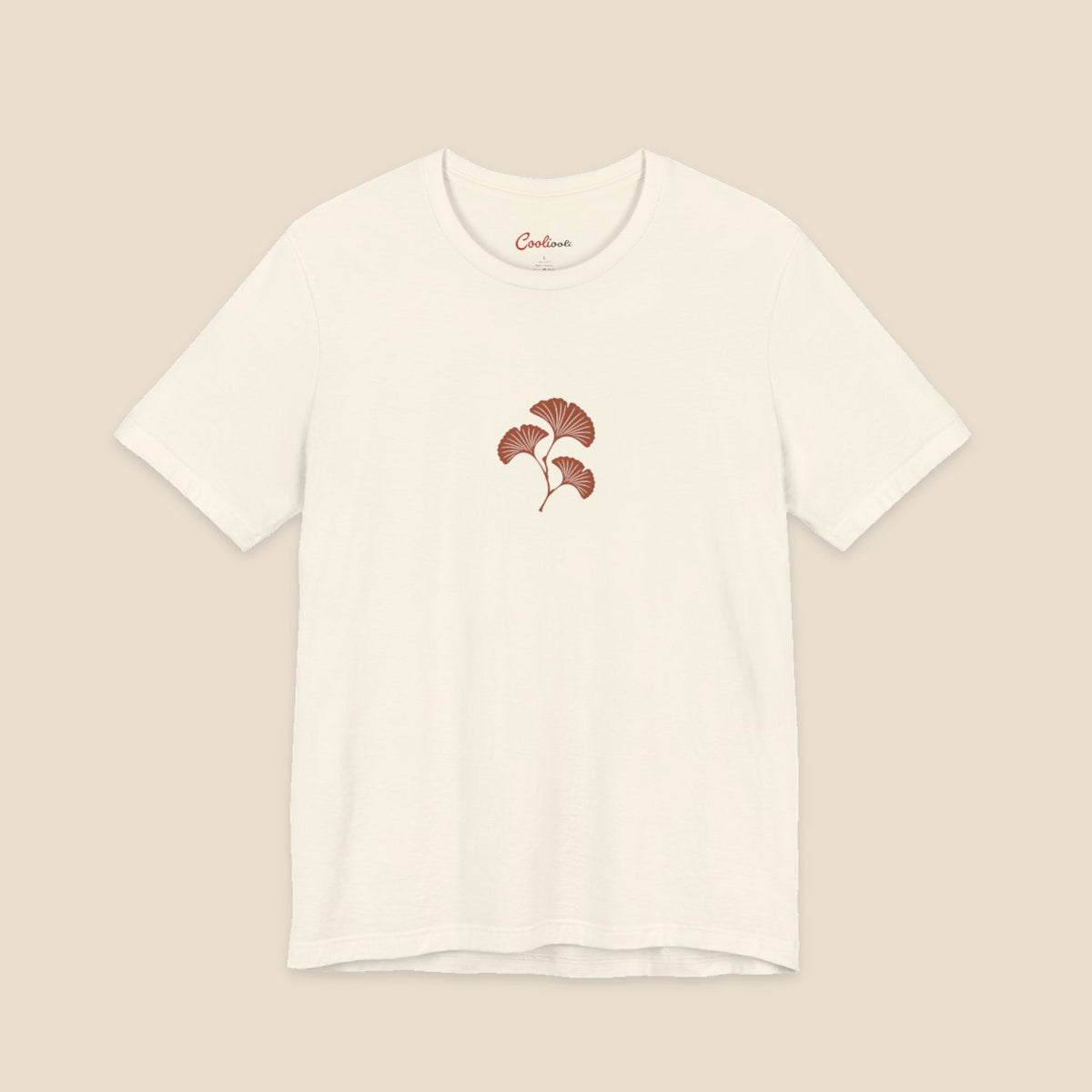 Natural Bella+Canvas 3001 T-shirt with an original small rust three-leaf ginkgo twig graphic.