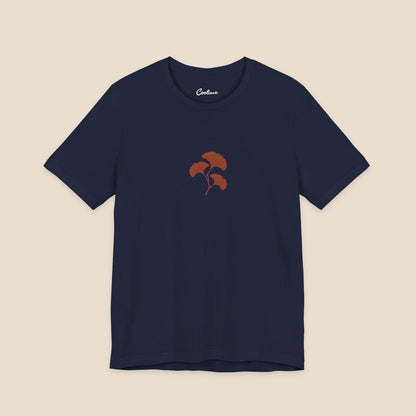 Navy Bella+Canvas 3001 T-shirt with an original small rust three-leaf ginkgo twig graphic.