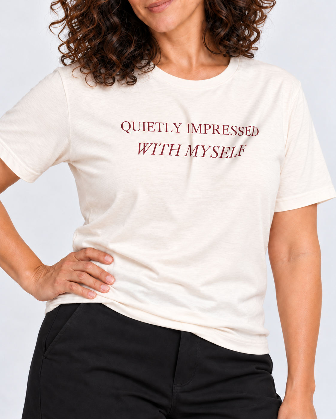 Close-up of the Natural Quietly Impressed With Myself tee, with wine serif print following the cotton folds.