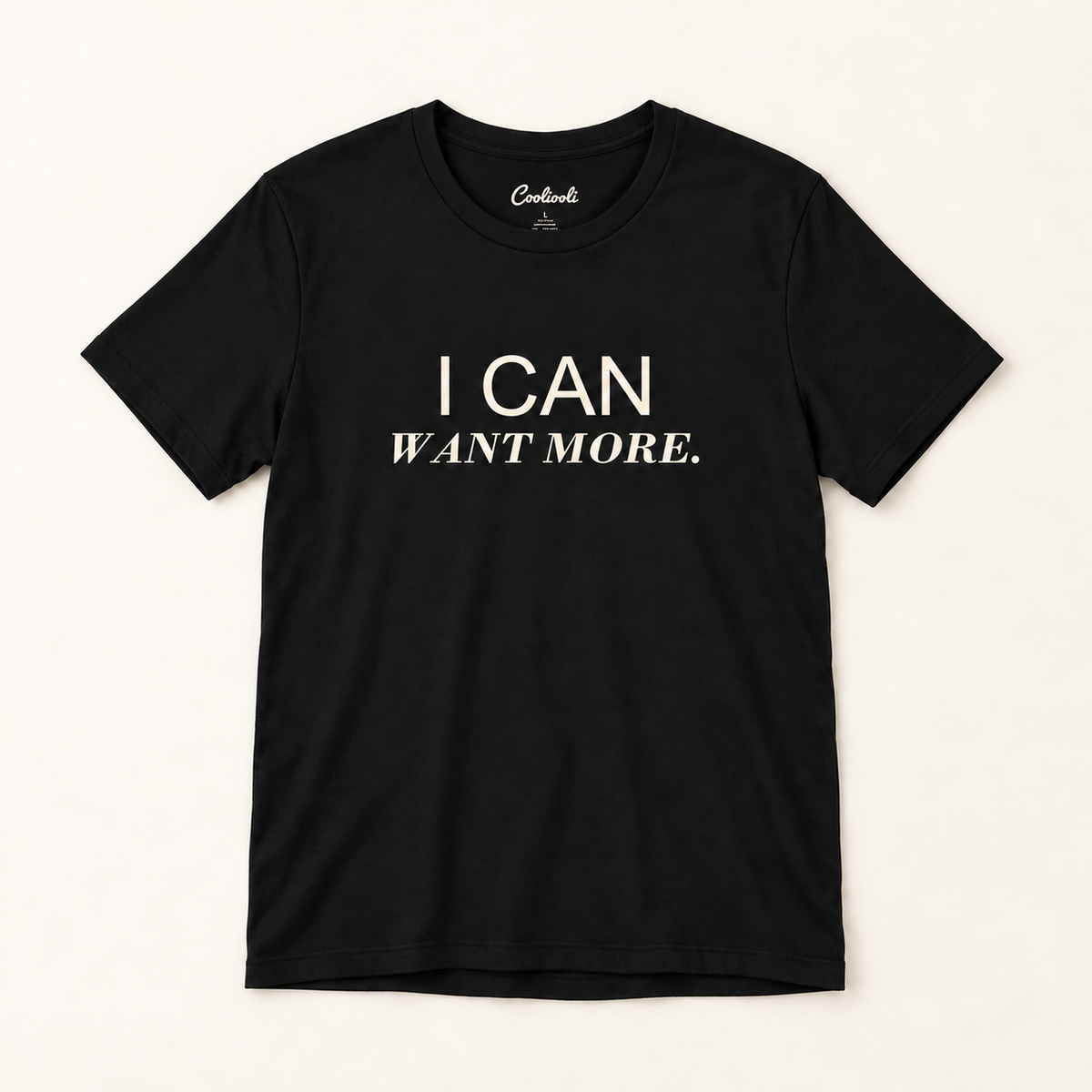 I CAN WANT MORE. Bella+Canvas 3001 tee in Black, overhead view on a plain warm neutral studio background