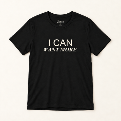 I CAN WANT MORE. Bella+Canvas 3001 tee in Black, overhead view on a plain warm neutral studio background