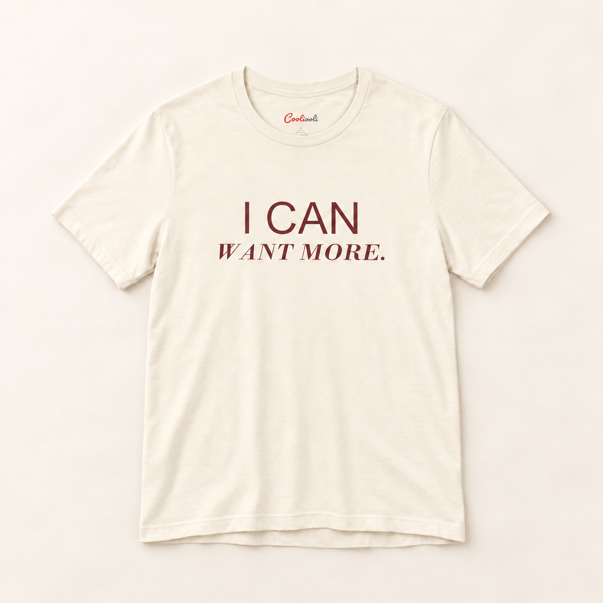 I CAN WANT MORE. Bella+Canvas 3001 tee in Natural, overhead view on a plain warm neutral studio background