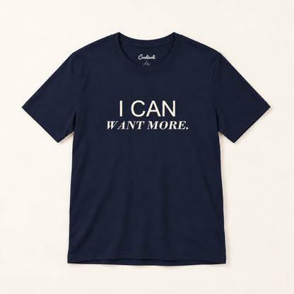 I CAN WANT MORE. Bella+Canvas 3001 tee in Navy, overhead view on a plain warm neutral studio background