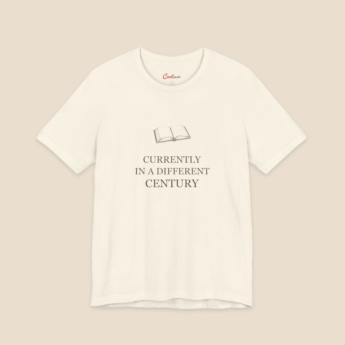 Natural Bella+Canvas 3001 reader T-shirt with an original open-book illustration and Currently in a Different Century lettering.