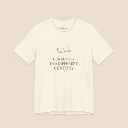 Natural Bella+Canvas 3001 reader T-shirt with an original open-book illustration and Currently in a Different Century lettering.
