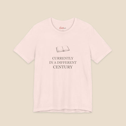 Soft Pink Bella+Canvas 3001 reader T-shirt with an original open-book illustration and Currently in a Different Century lettering.