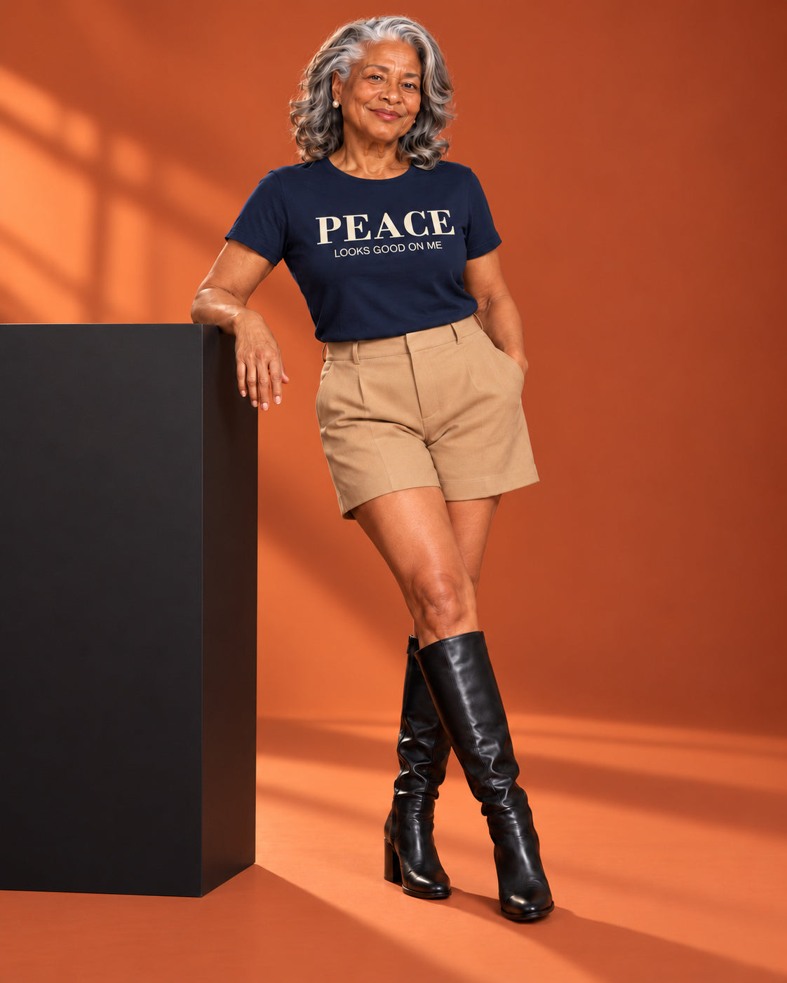 Vivienne wears the Peace Looks Good on Me affirmation tee in Navy with tailored shorts and tall boots.