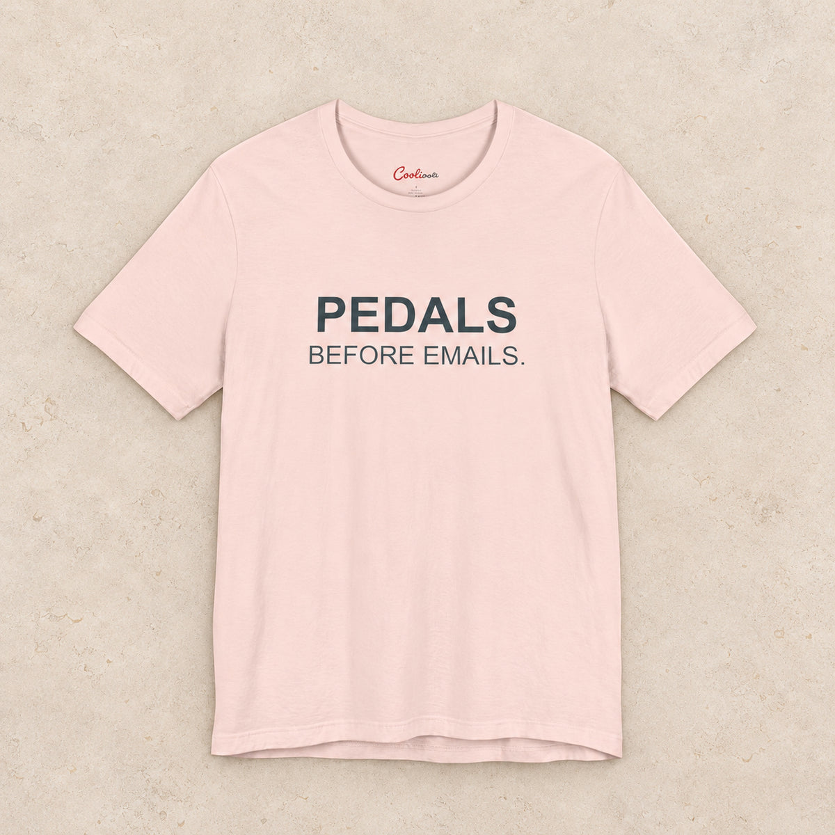 Pedals Before Emails. Bella+Canvas3001 T-shirt in Soft Pink, front flat lay.
