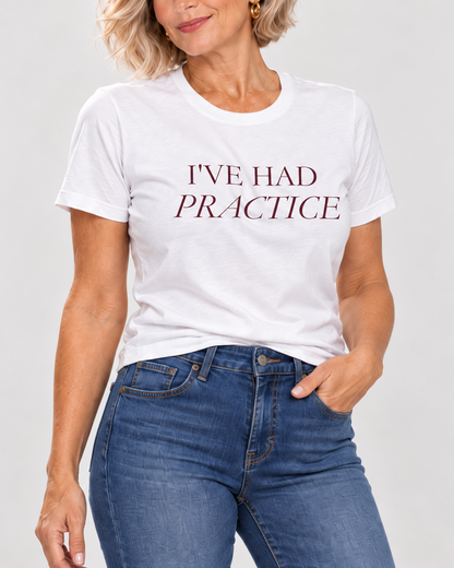 Close-up of the white I've Had Practice tee, showing burgundy serif lettering and the cotton fold.