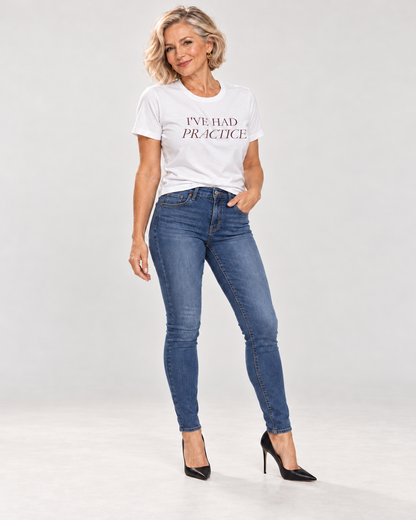 Claudia wearing the white I've Had Practice Bella+Canvas 3001 T-shirt with very fitted blue skinny jeans and black pointed heels.