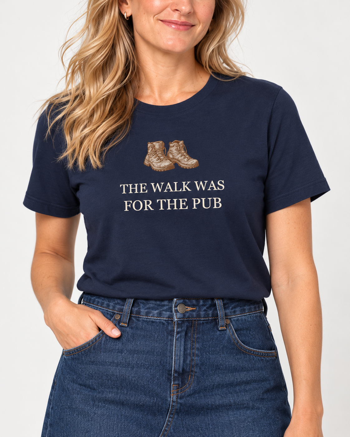 Collar-to-hip detail of the Navy walking and pub T-shirt, showing brown hiking boots and cream The Walk Was for the Pub lettering.