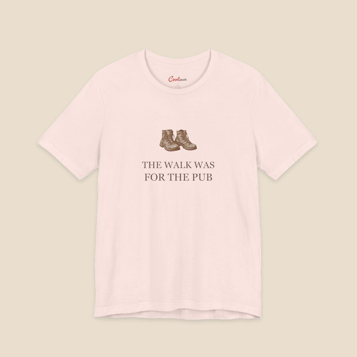 Soft Pink Bella+Canvas3001 T-shirt with a brown hiking boots graphic and The Walk Was for the Pub serif lettering.