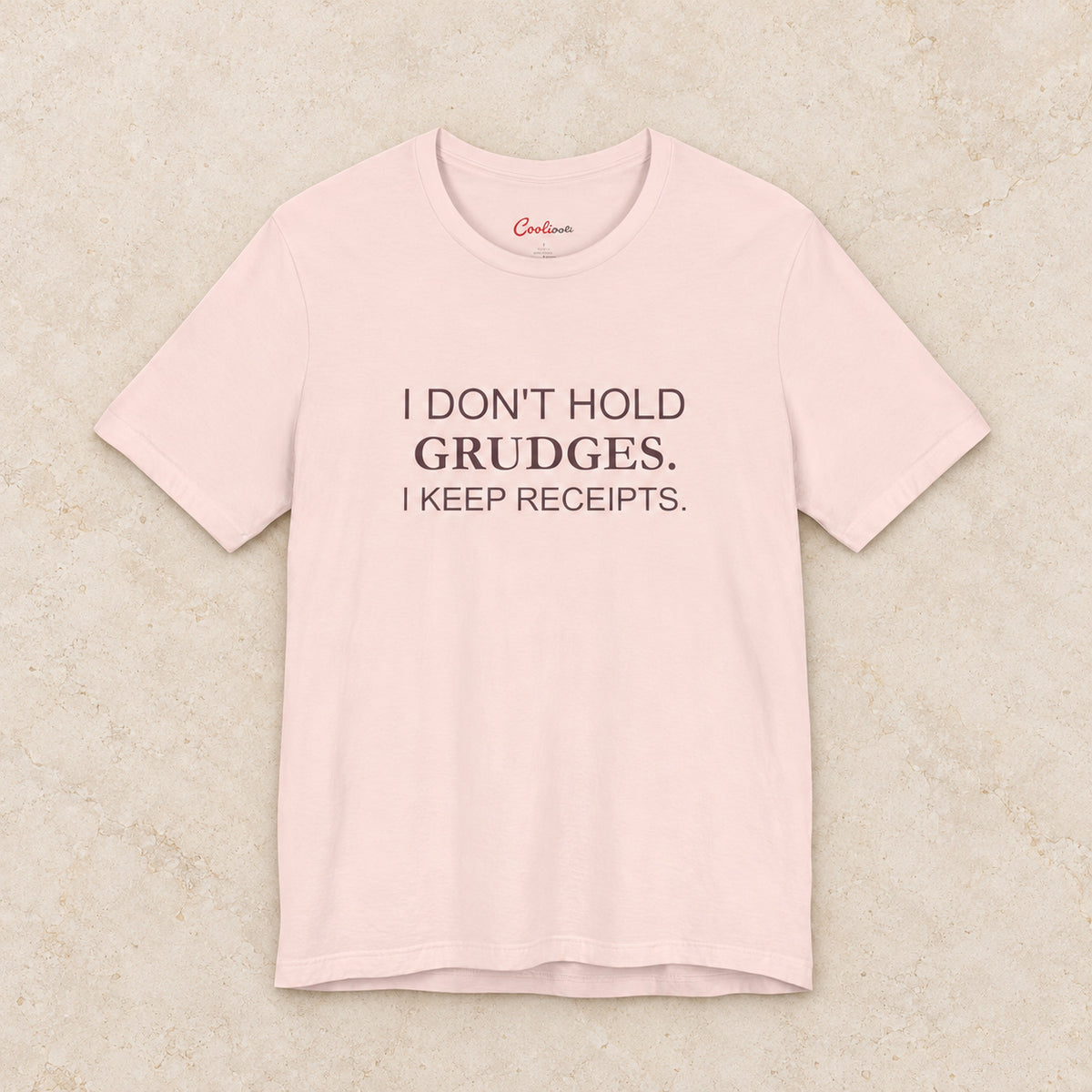 I Don't Hold Grudges. I Keep Receipts. Bella+Canvas3001 T-shirt in Soft Pink, front flat lay.