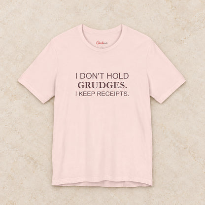 I Don't Hold Grudges. I Keep Receipts. Bella+Canvas3001 T-shirt in Soft Pink, front flat lay.