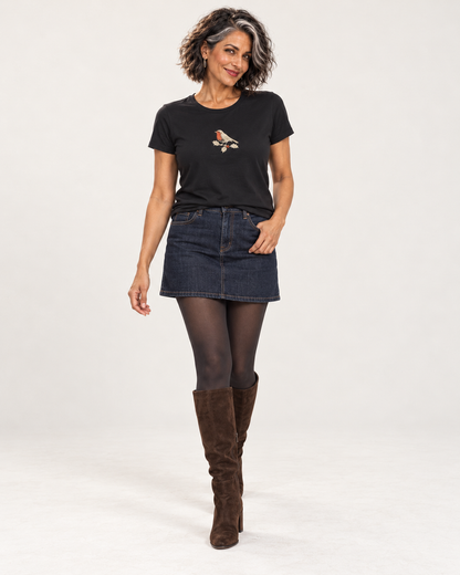 Freya wearing the Black robin and holly Christmas T-shirt with a denim mini skirt, opaque tights and tall brown suede boots.