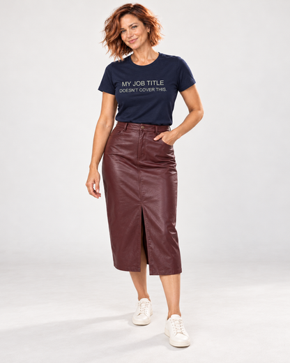 Sienna wearing the Navy My Job Title Doesn’t Cover This T-shirt with a burgundy leather-look midi skirt and cream trainers in the pale studio.