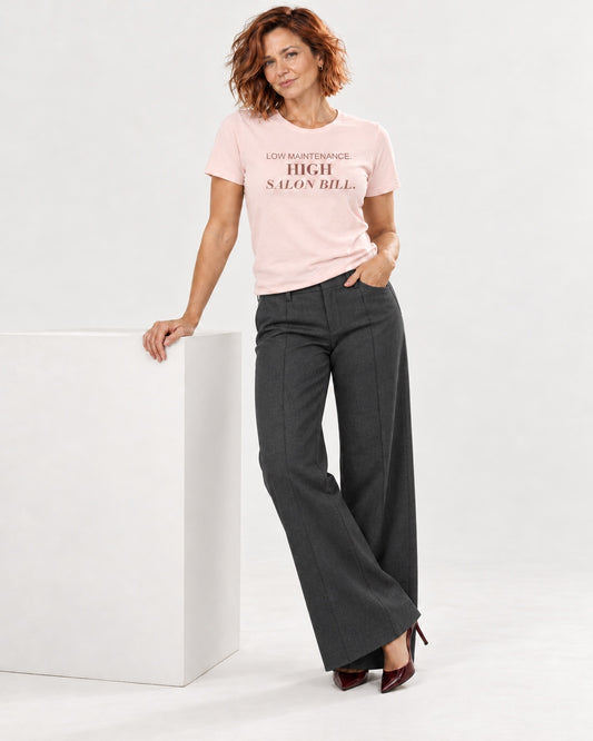 Sienna wearing the Soft Pink LOW MAINTENANCE. HIGH SALON BILL. Bella+Canvas 3001 tee — full-length natural studio outfit