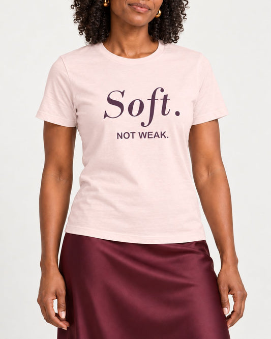 Amara wearing the Soft Pink Softness Is Her Strength. Bella+Canvas 3001 tee — collar-to-hip detail with ink following fabric folds
