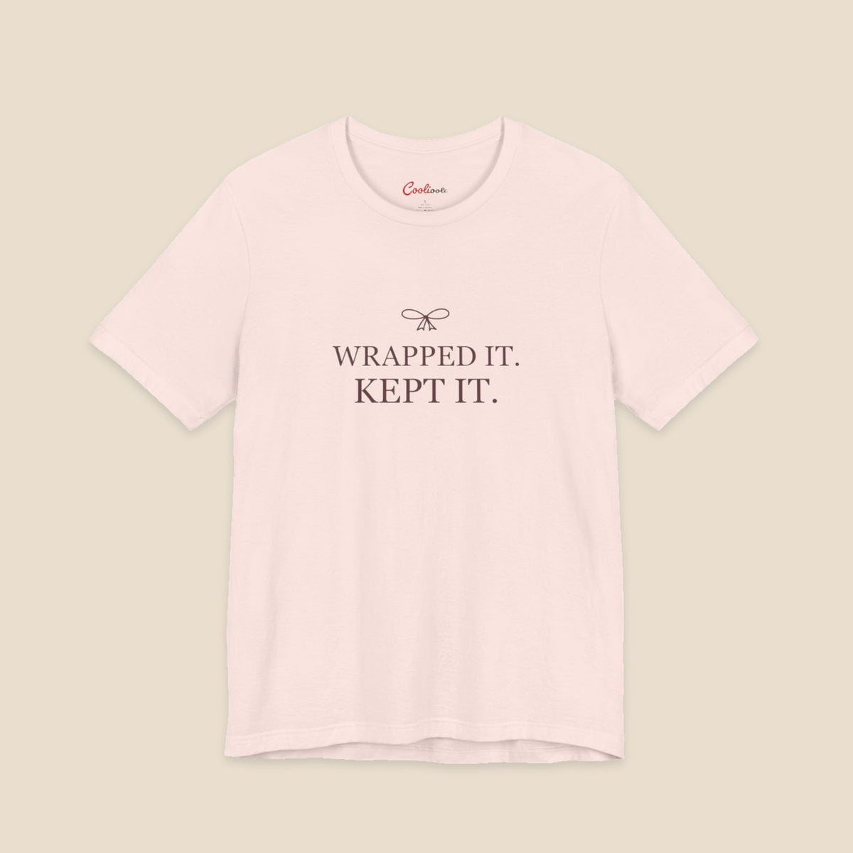 Soft Pink Bella+Canvas 3001 T-shirt with Wrapped It. Kept It. lettering and a small ribbon bow.