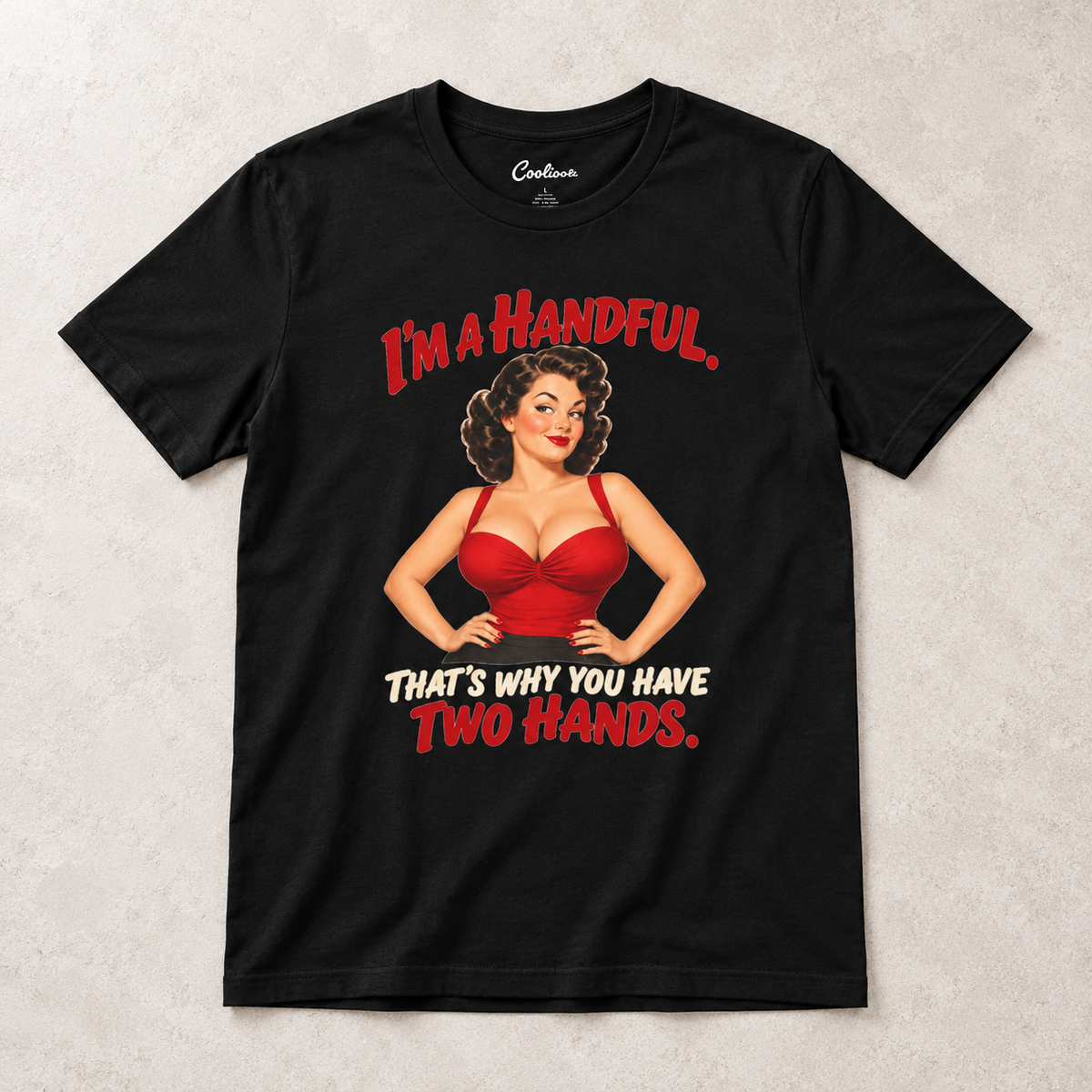 Black Cooliooli T-shirt with the “I’m a handful. That’s why you have two hands.” pin-up design, front flat lay