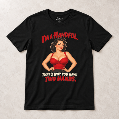 Black Cooliooli T-shirt with the “I’m a handful. That’s why you have two hands.” pin-up design, front flat lay