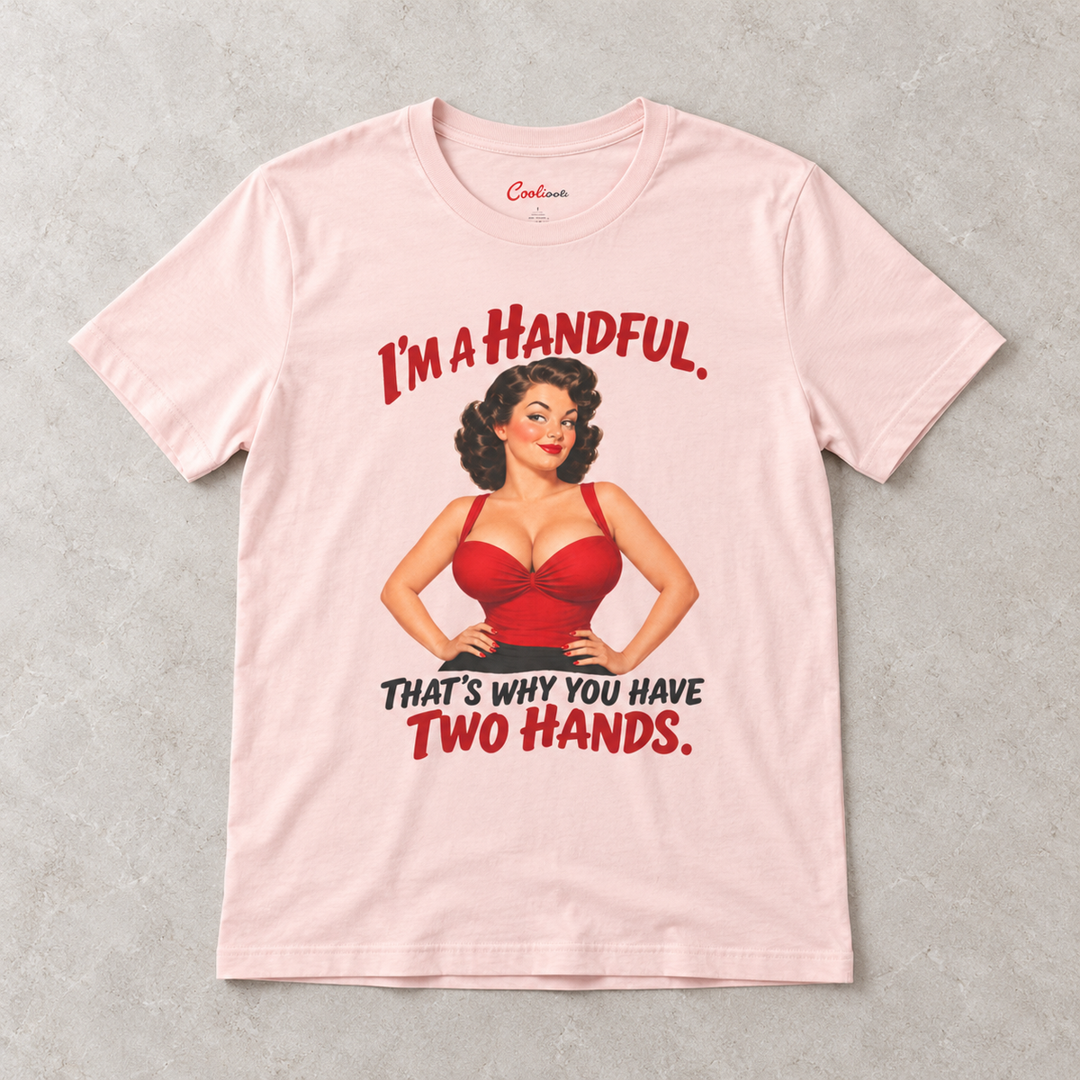 Soft Pink Cooliooli T-shirt with the “I’m a handful. That’s why you have two hands.” pin-up design, front flat lay