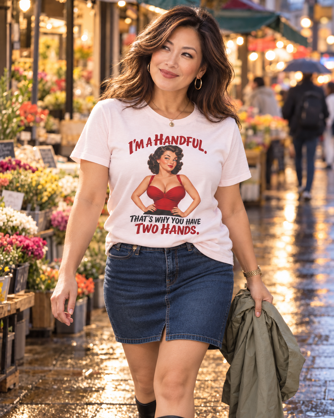 Lucy wearing a Soft Pink Cooliooli T-shirt with the “I’m a handful. That’s why you have two hands.” design and a short denim skirt at an evening flower market