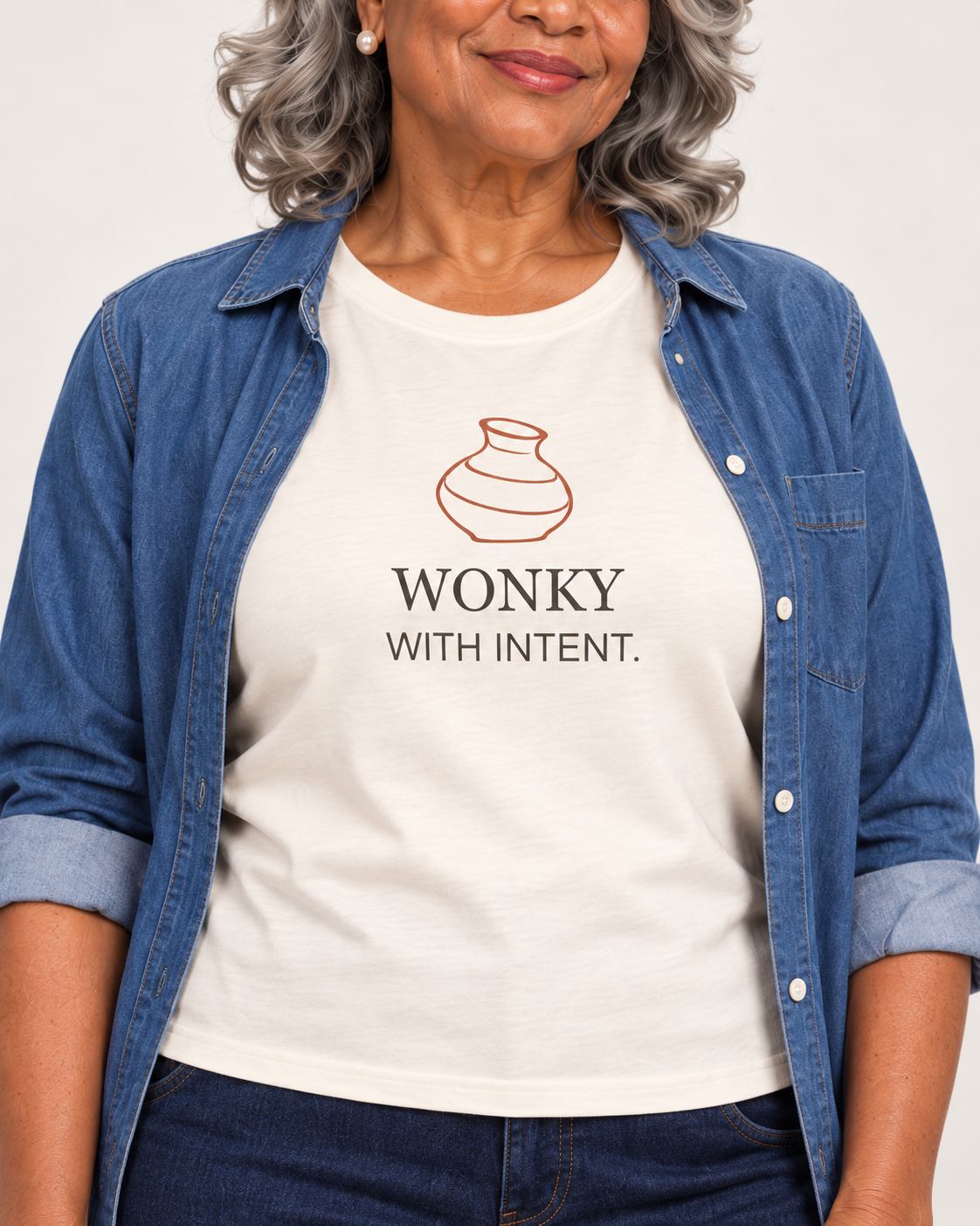 Close view of the terracotta vase and WONKY WITH INTENT. print on the Natural Bella+Canvas 6400 women’s relaxed-fit tee.