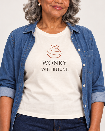 Close view of the terracotta vase and WONKY WITH INTENT. print on the Natural Bella+Canvas 6400 women’s relaxed-fit tee.